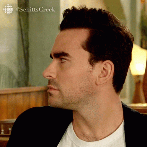a close up of a man 's face with #schittscreek written on the bottom right's face with #schittscreek written on the bottom right