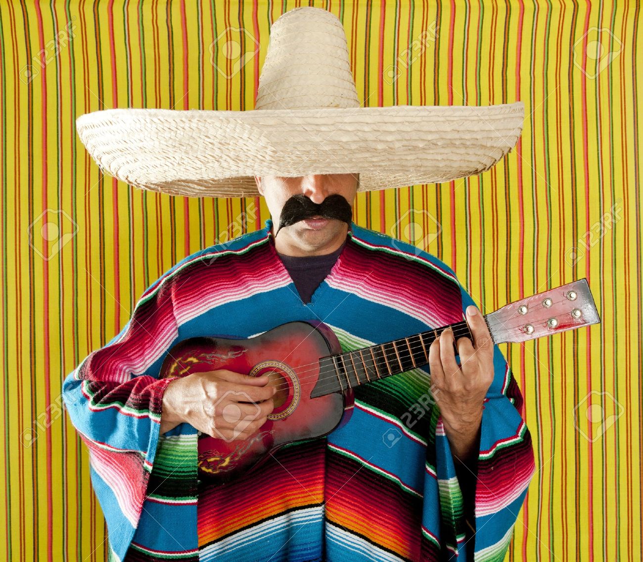 9706258-Mexican-man-serape-poncho-sombrero-playing-guitar-typical-Mexico-Stock-Photo.jpg